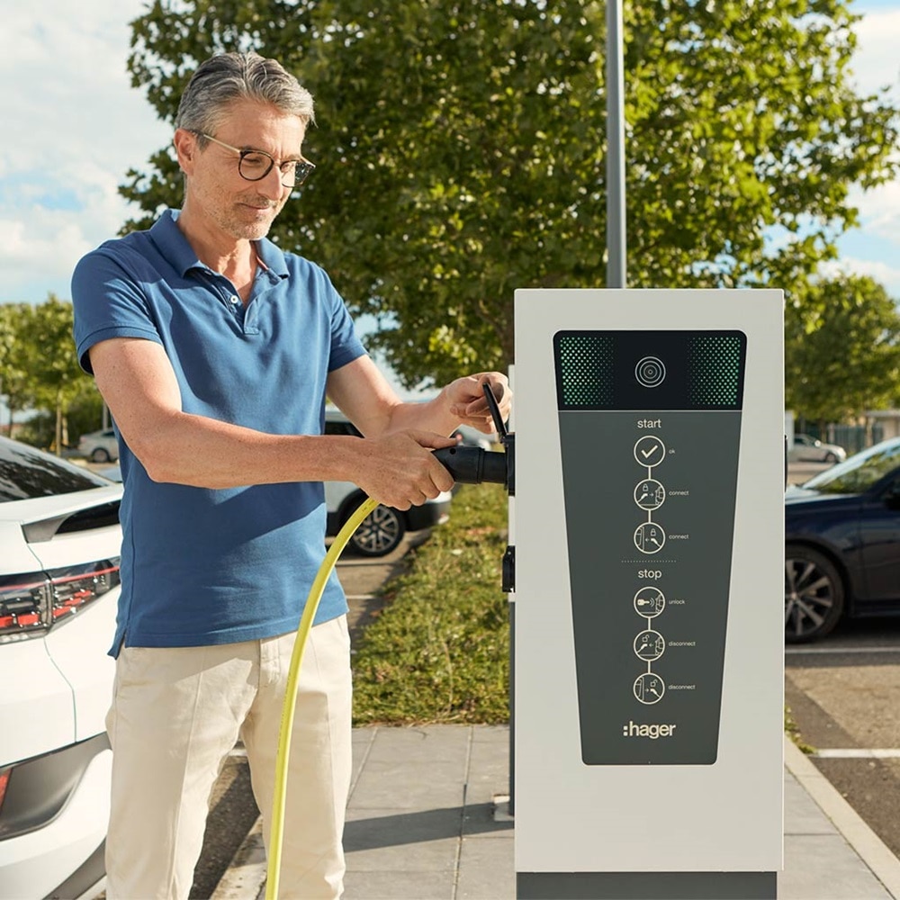 Mann, der Ladeskabel für das Elektroauto an die Hager Witty Park Ladesäule anschließt