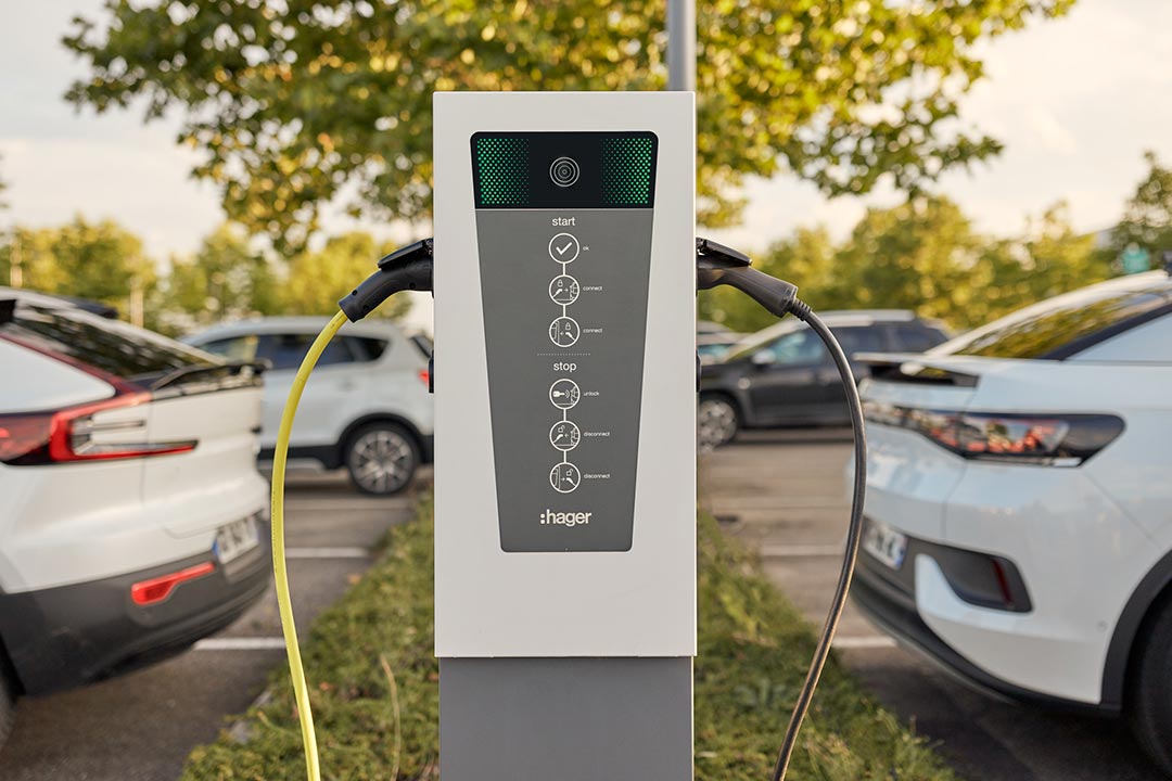 Frontalansicht der Hager Witty Ladesäule mit eingesteckten Ladekabeln von Elektroautos links und rechts, Variante 2