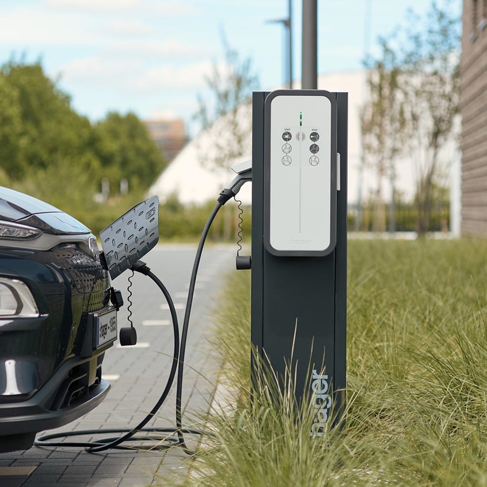 Hager Witty Share Ladesäule im Freien, an die ein Elektroauto über ein Ladekabel angeschlossen ist