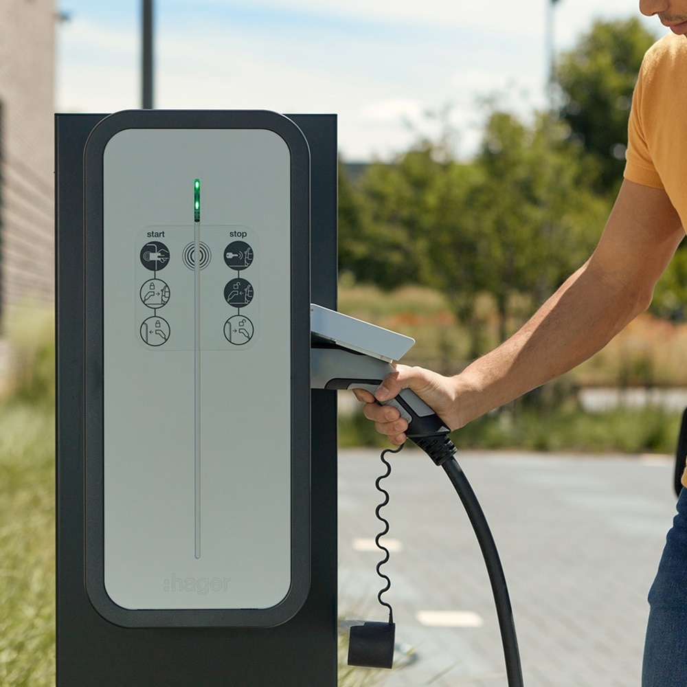 Mann, der Ladeskabel für das Elektroauto an die Hager Witty Share Ladesäule anschließt