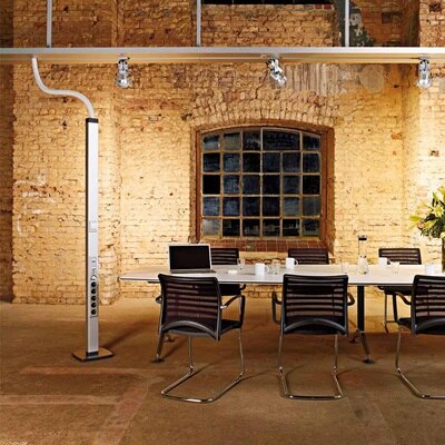 Blick in Konferenzraum mit Ziegelsteinmauer und Hager Deckenanschlusssäule thealit DA mit integrierten Steckdosen / Netzwerkdosen