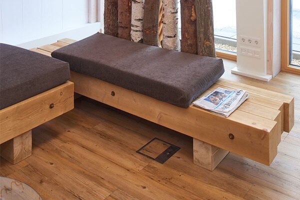 Blick in Raum mit Sitzbank und im Boden flächenbündig integrierte Installationsdose für Energie- und Daten-Einbaugeräte 