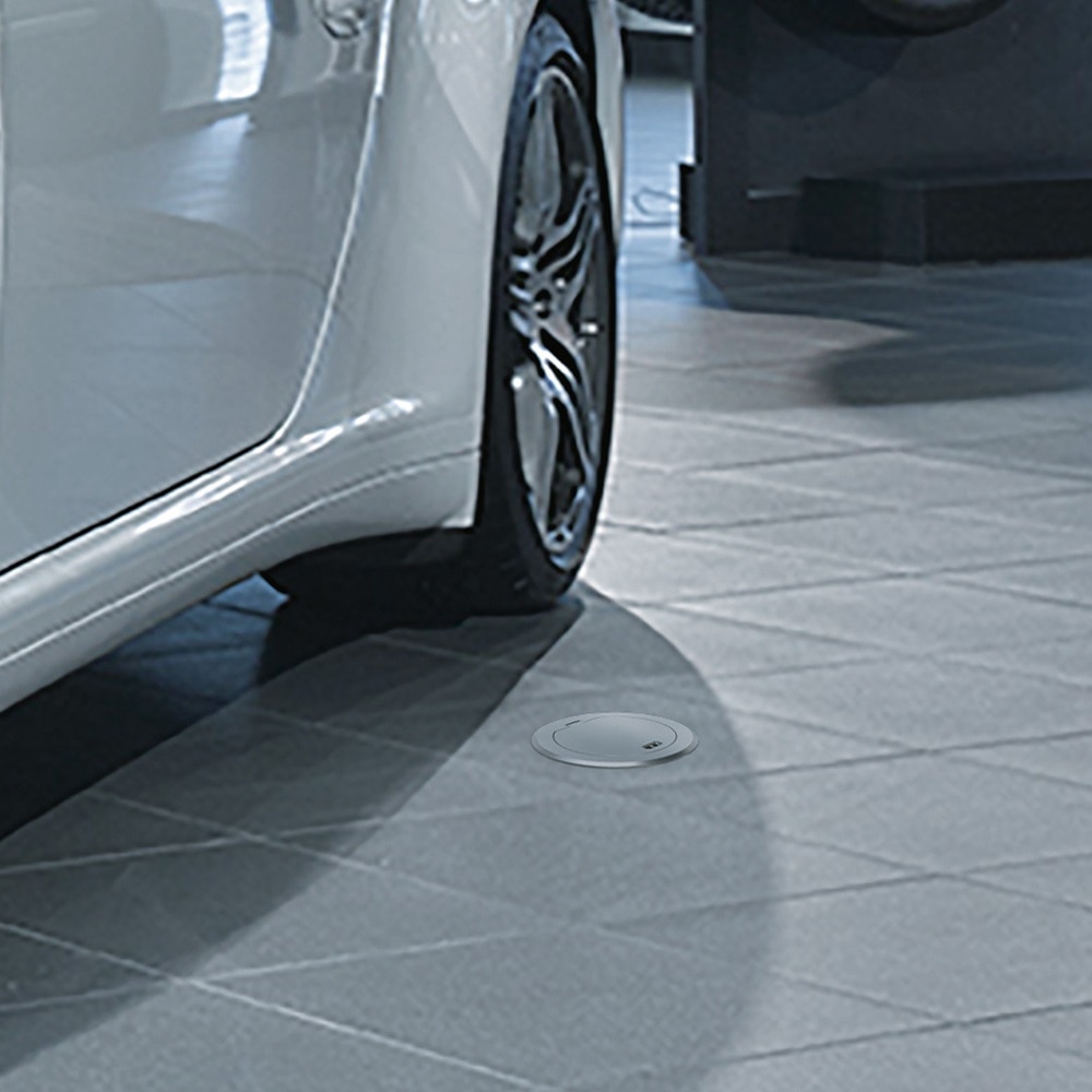 Blick auf gefliesten Boden in Auto Showroom mit flächenbündig installierter silberner Installationsdose von Hager