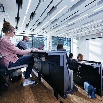 Blick in Vorlesungsraum mit Personen, unterhalb der Tische ist ein Hager tehalit Brüstungskanal in Blau zu sehen