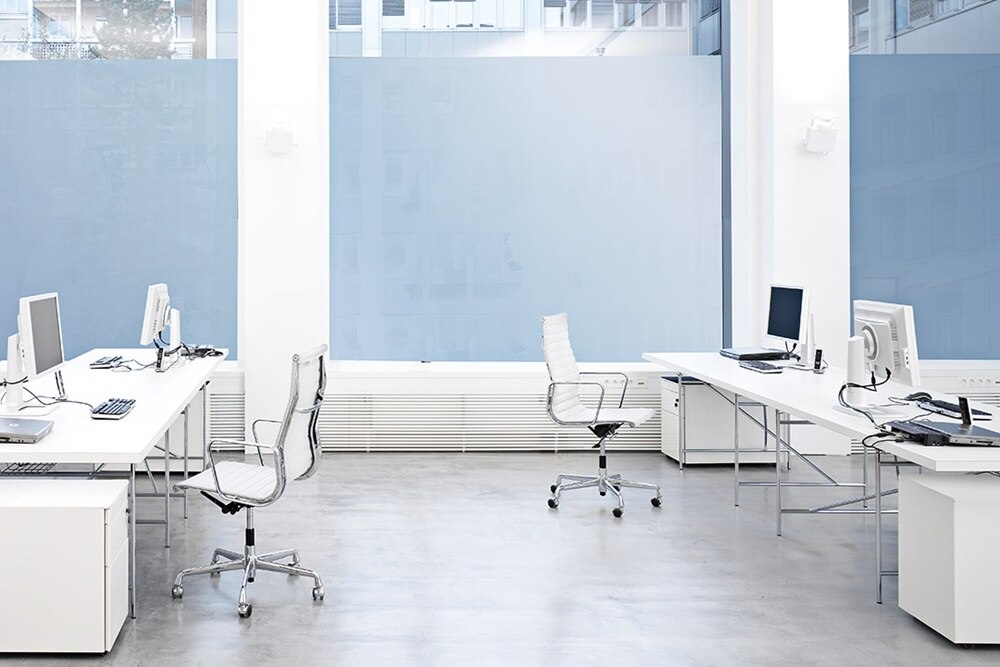 Blick in großes Büro mit weißer Ausstattung der Möbel und EDV-Systeme