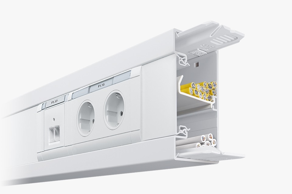 Querschnittsansicht eines weißen Elektrokanalsystems mit integrierten Steckdosen und Verdrahtungsklemmen