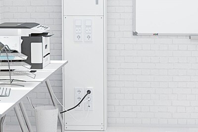 Blick in Klassenzimmer mit Fokus auf unteren Bereich der Hager Mediensäule mit Einbaugeräten wie Steckdosen und Schaltern