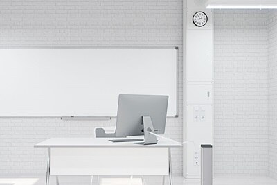 Blick in Klassenzimmer mit Hager Mediensäule im Hintergrund, davor Arbeitsplatz mit Standsäule für Arbeitsplatzanschluss (Rückansicht)