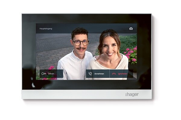 Weiße Video Innenstation Hager intercom view mit Touch-Display worauf ein Mann und eine Frau zu sehen sind, die vor der Haustür an der Außenstation stehen