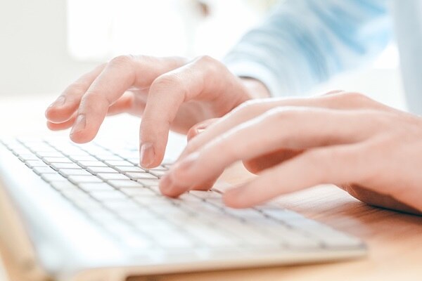 Nahaufnahme einer Person beim Tippen auf einer Computertastatur