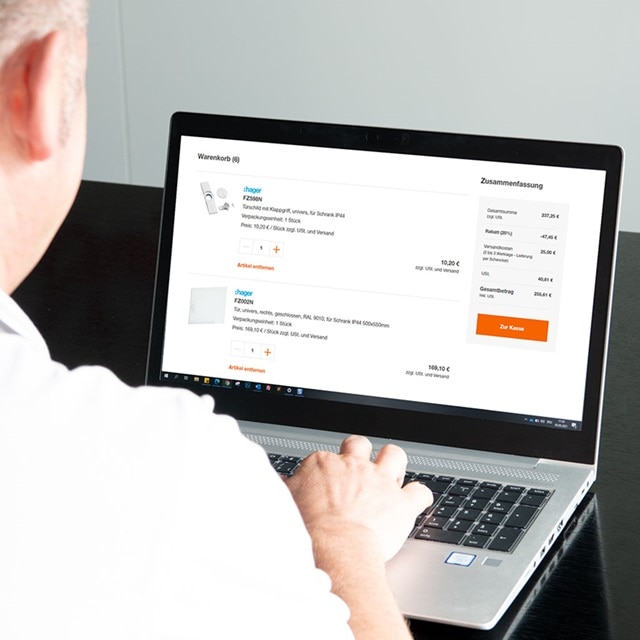 Person benutzt einen Laptop, der Hager-Produkte in einem Online-Warenkorb anzeigt