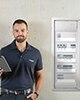 Techniker mit Tablet neben einer elektrischen Verteilertafel stehend