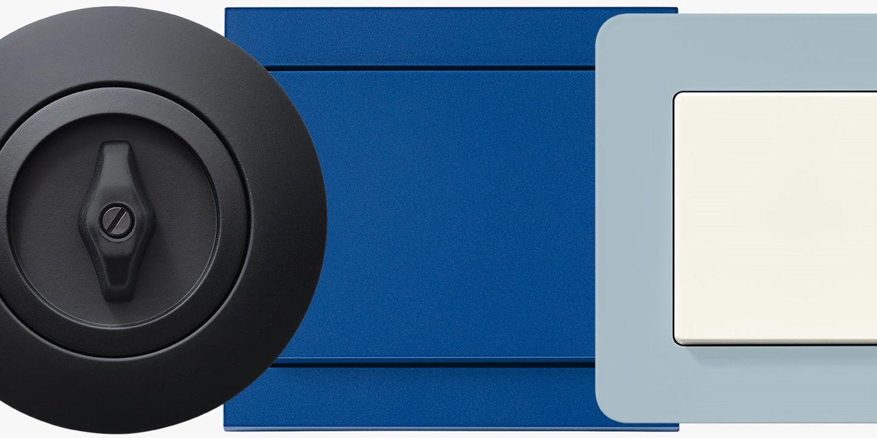 Nahaufnahme eines modernen elektrischen Schlüsselschalters und Lichtschalters vor blauem Hintergrund