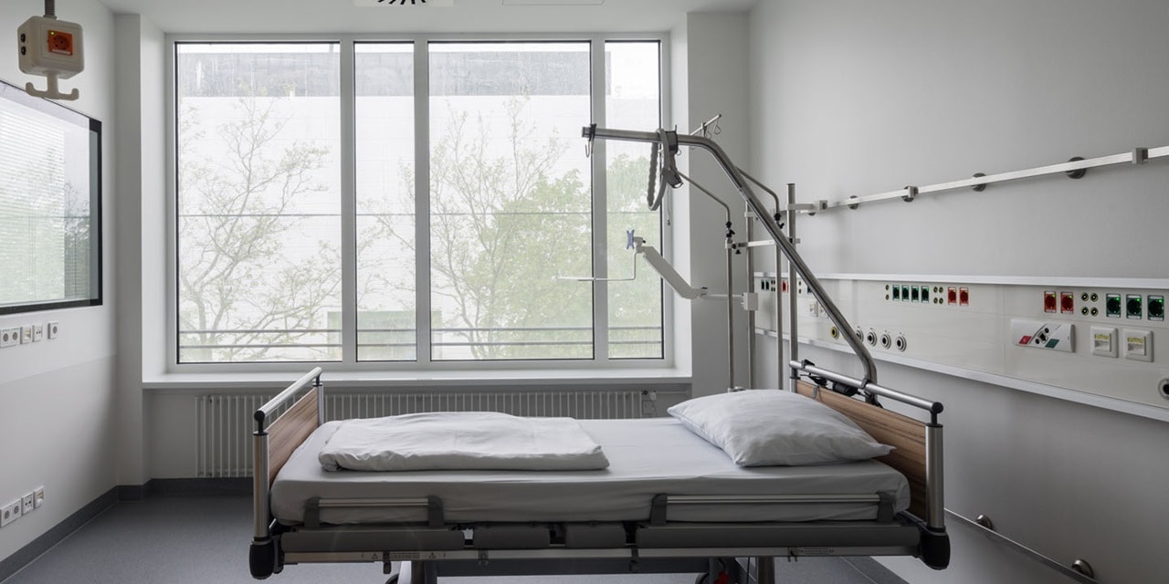 Modernes Krankenhauszimmer mit verstellbarem Bett und elektrischen medizinischen Geräten an der Wand