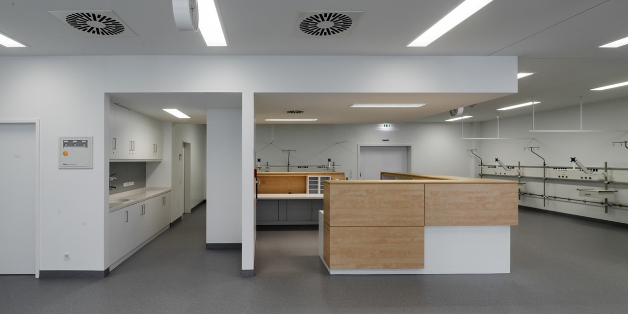 Modernes Laborinnenraum mit elektrischem Steuerungspanel, Deckenbeleuchtung und Arbeitsstationen