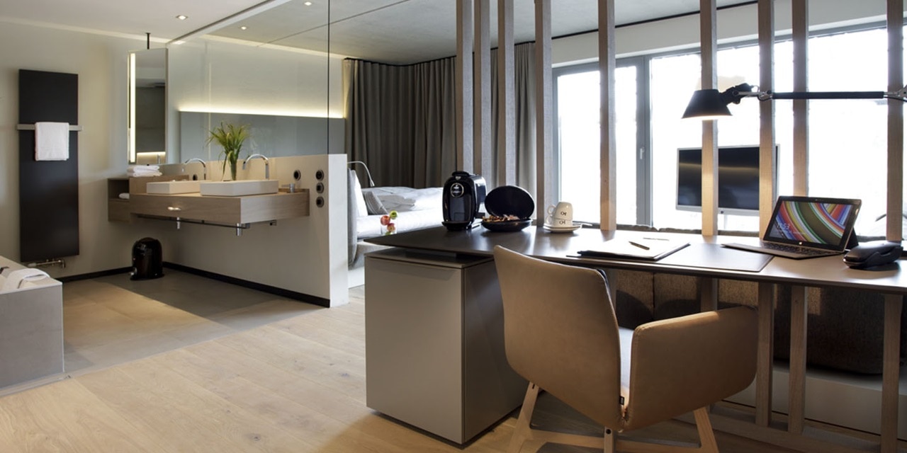 Moderne Hotel-Suite mit offenem Grundriss, integriertem Arbeitsplatz, Kochnische und Schlafbereich, ausgestattet mit zeitgenössischen Möbeln und elektrischen Geräten