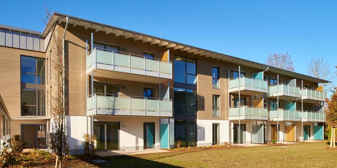 Modernes Wohngebäude mit Balkonen vor klarem blauem Himmel