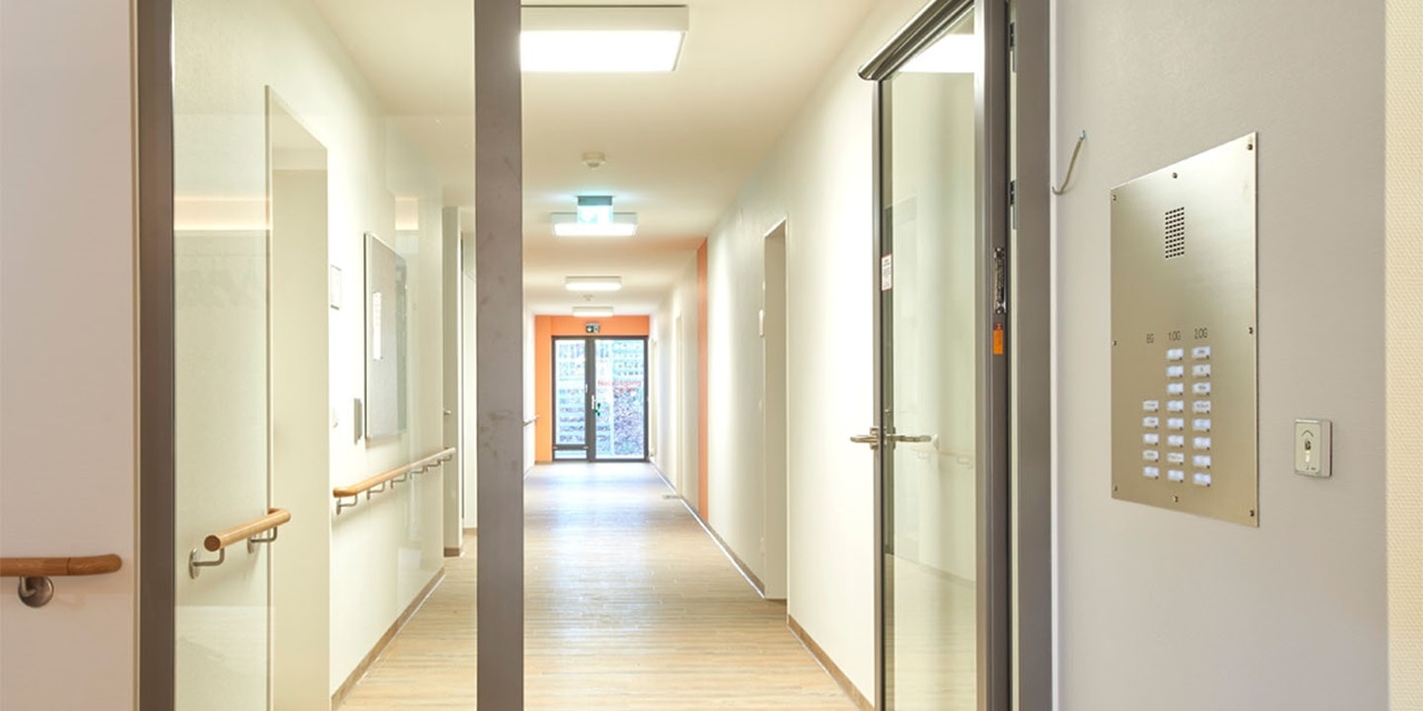 Moderner Gebäudeflur mit Türen, Beleuchtung und wandmontiertem Gegensprechanlagensystem