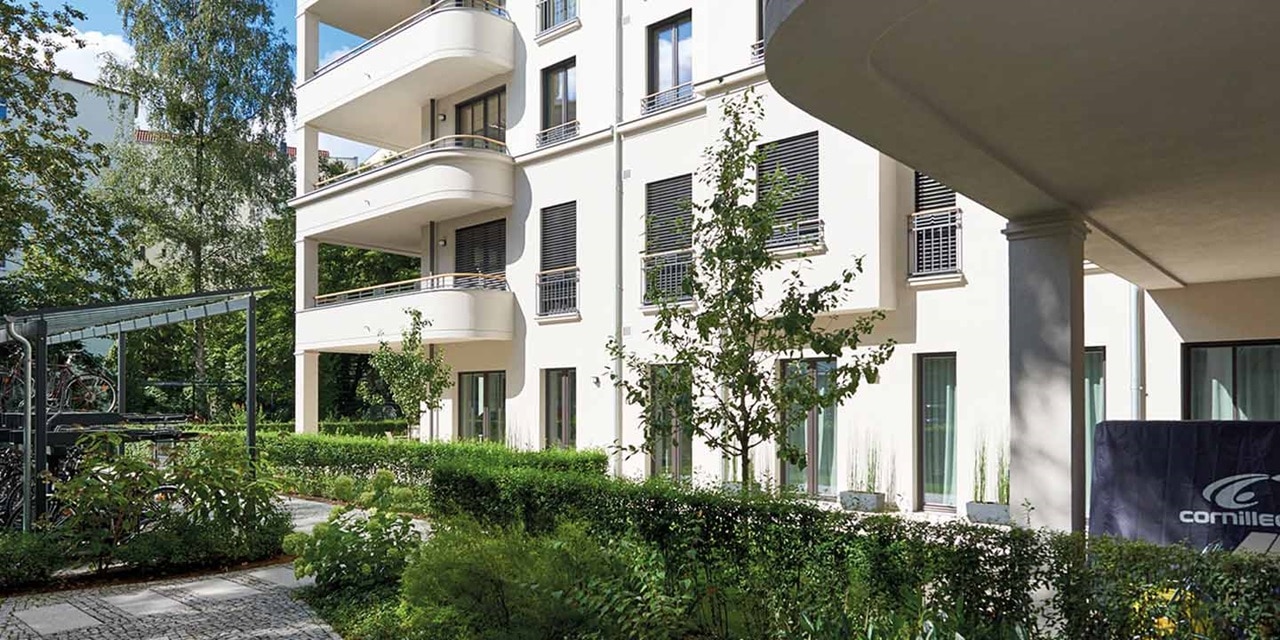 Modernes Wohngebäude mit Balkonen und einem grünen Innenhof