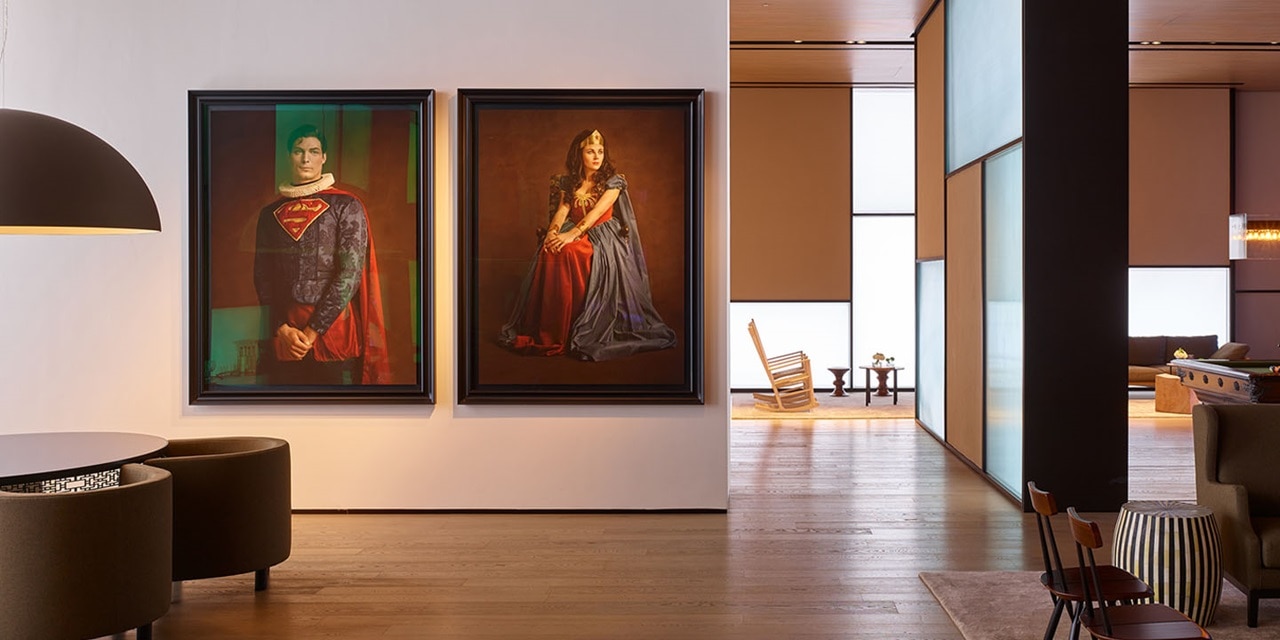 Elegantes Innendesign eines Wohnraums mit zwei großen gerahmten Porträts, modernen Möbeln und atmosphärischer Beleuchtung