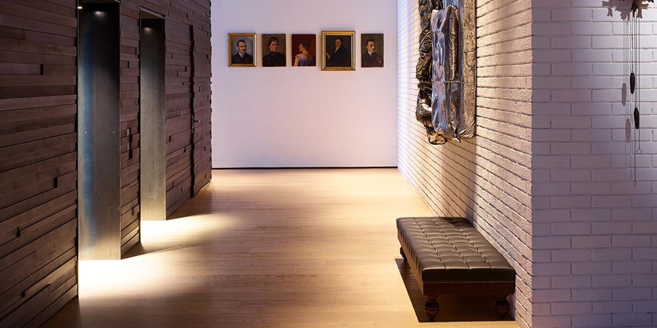 Modernes Galerieinterieur mit Spotbeleuchtung, Wandkunst und Sitzbank