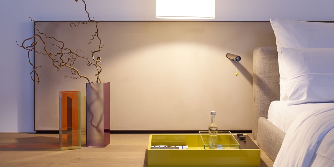 Modernes Schlafzimmer-Interieur mit dekorativer Wandkunst und verstellbarer Spotlampe