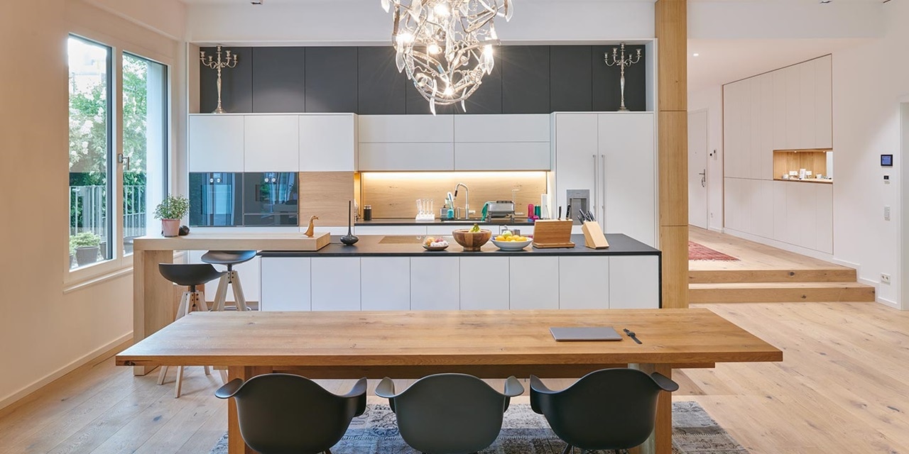 Modernes Kücheninterieur mit LED-Unterschrankbeleuchtung, Design-Hängeleuchte und Holzmöbeln