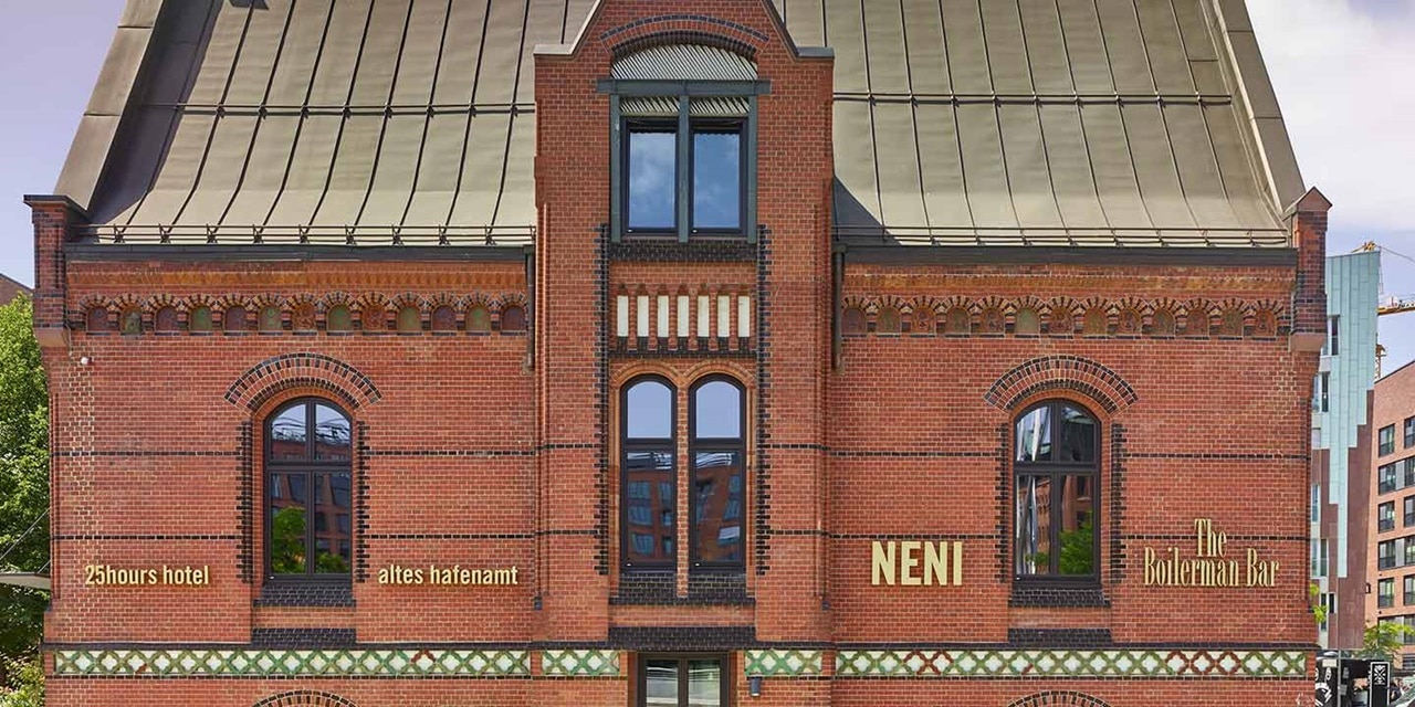 Ziegelsteinfassade eines historischen Gebäudes mit Beschilderung für '25hours hotel', 'NENI' und 'The Boilerman Bar'