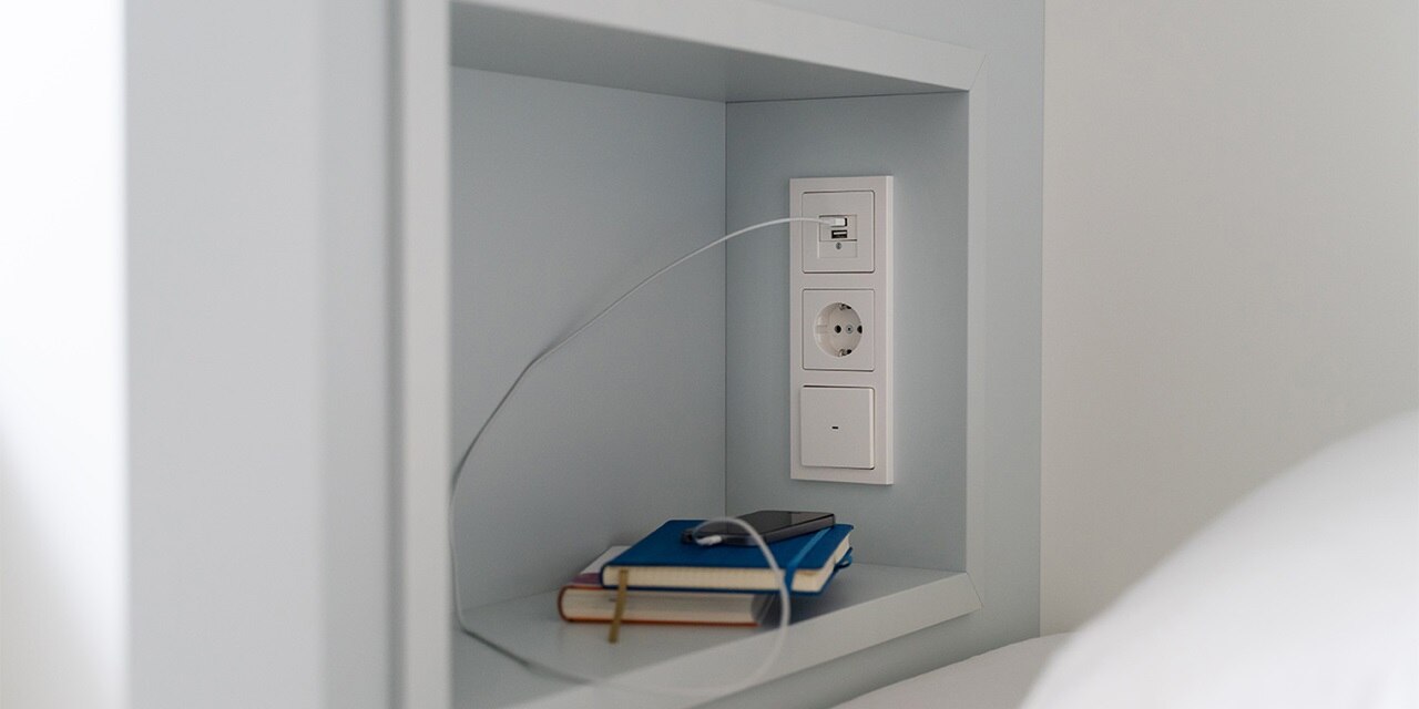 Moderne elektrische Wandsteckdose mit USB-Ladegerät und Stromanschluss im minimalistischen Interieur