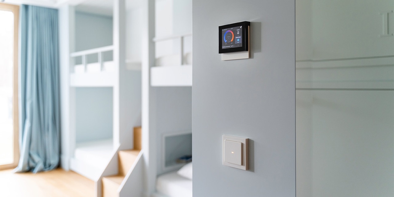 Modernes Wohninterieur mit Smart-Home-Steuerungspanel an der Wand und Lichtschalter