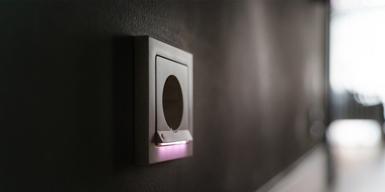 Moderner Lichtschalter an einer dunklen Wand mit LED-Anzeige