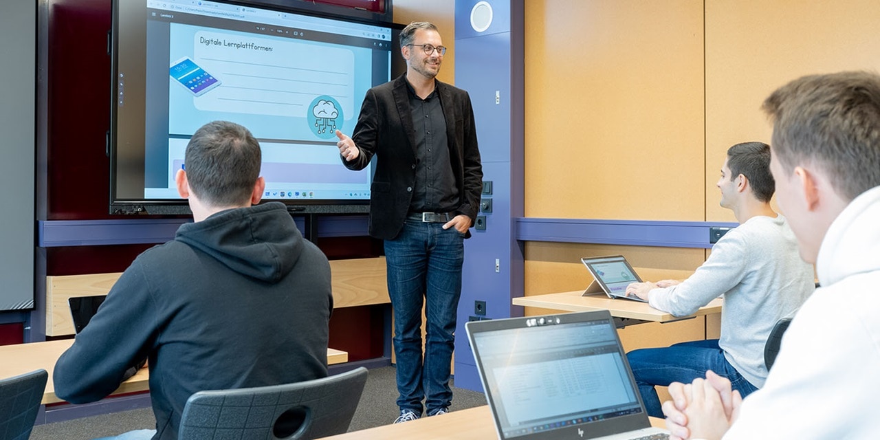 Schulungssitzung mit Präsentator und Teilnehmern in einem modernen Klassenzimmer mit digitalem Präsentationsbildschirm