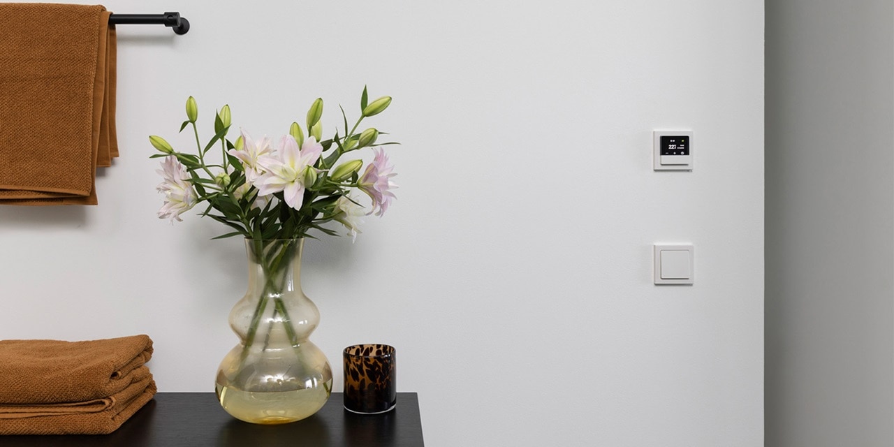 Modernes Wohninterieur mit intelligentem Thermostat und Lichtschalter an der Wand