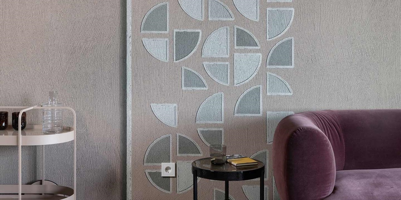 Modernes Wohnzimmer mit geometrischer Tapete, weichem lila Sofa und einer weißen Steckdose an der Wand