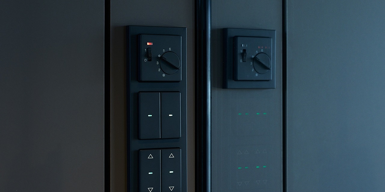 Moderne Smart-Home-Steuerungspanele mit Schaltern, Drehreglern und Statusanzeigen an einer dunklen Wand