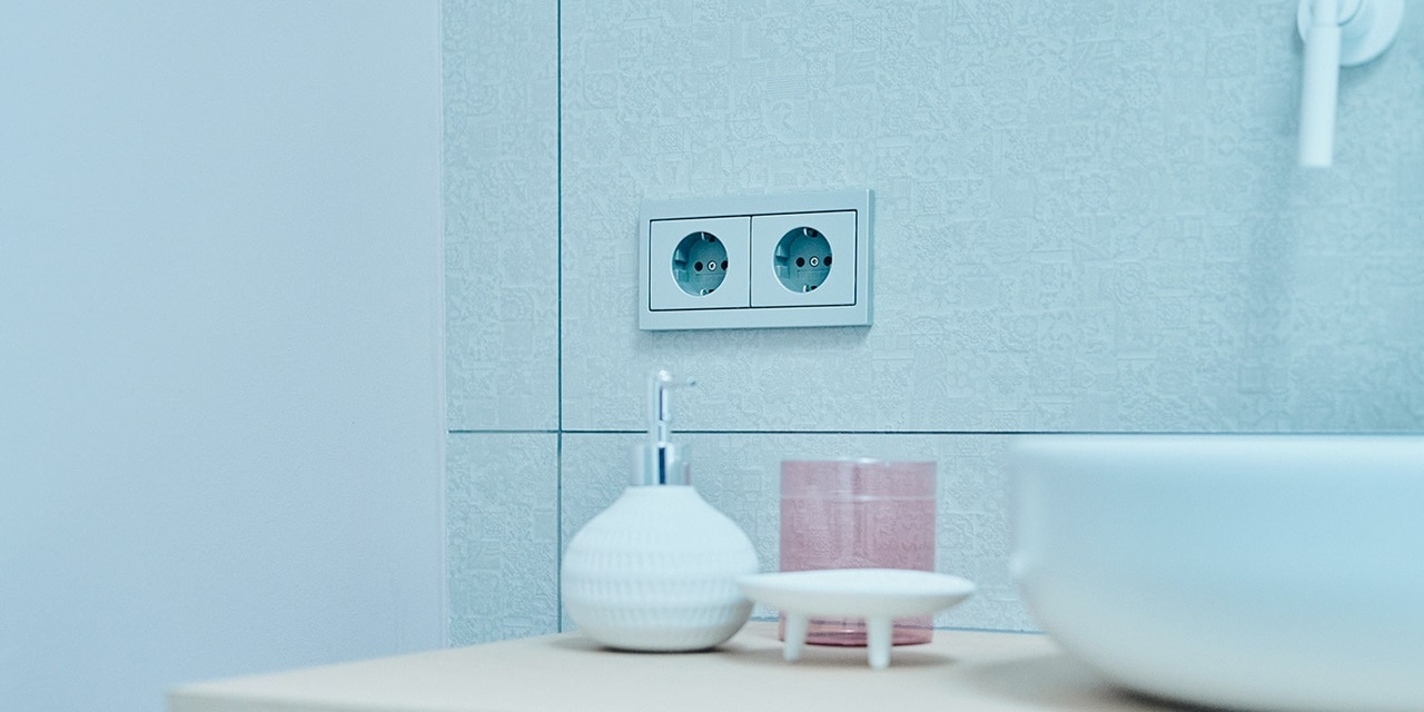 Modernes Badezimmerinterieur mit Doppelsteckdose an gefliester Wand
