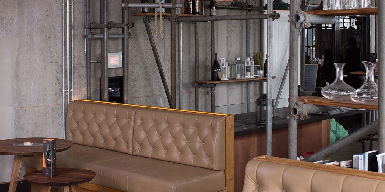 Modernes Café-Interieur mit industriellen Designdetails und sichtbarem wandmontiertem Stromverteiler