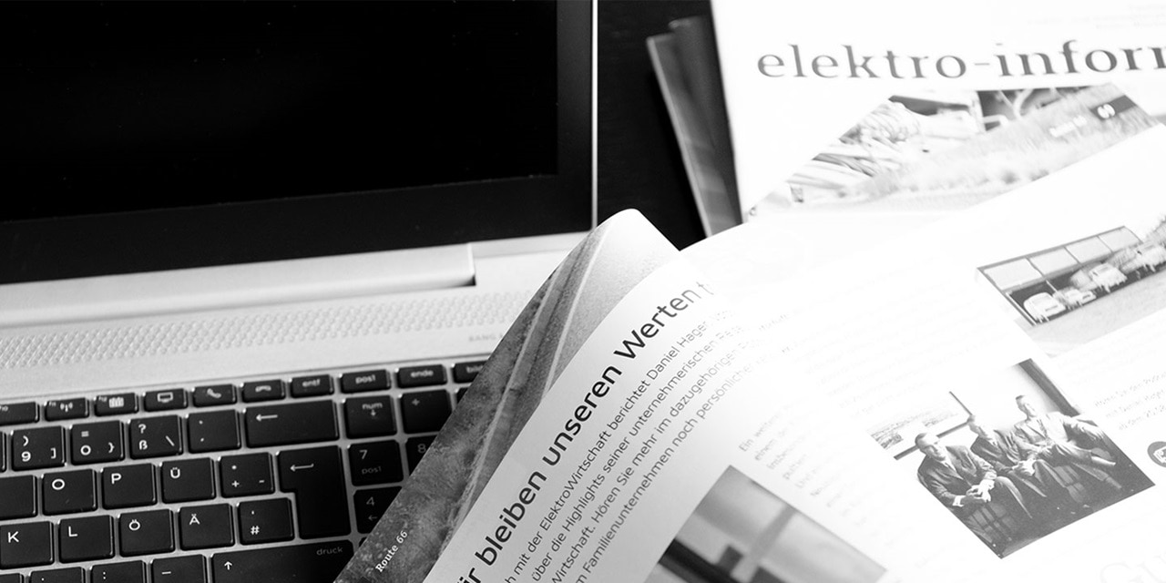 Schwarz-Weiß-Foto einer Laptop-Tastatur mit Zeitschriften über Elektroinformation