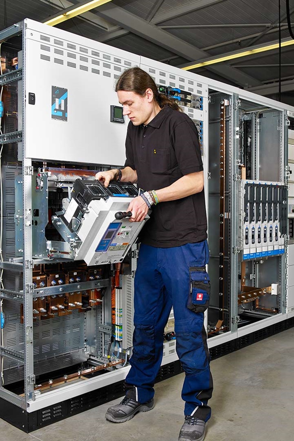 Eine Elektrofachkraft, die einen Leistungsschalter wartet.