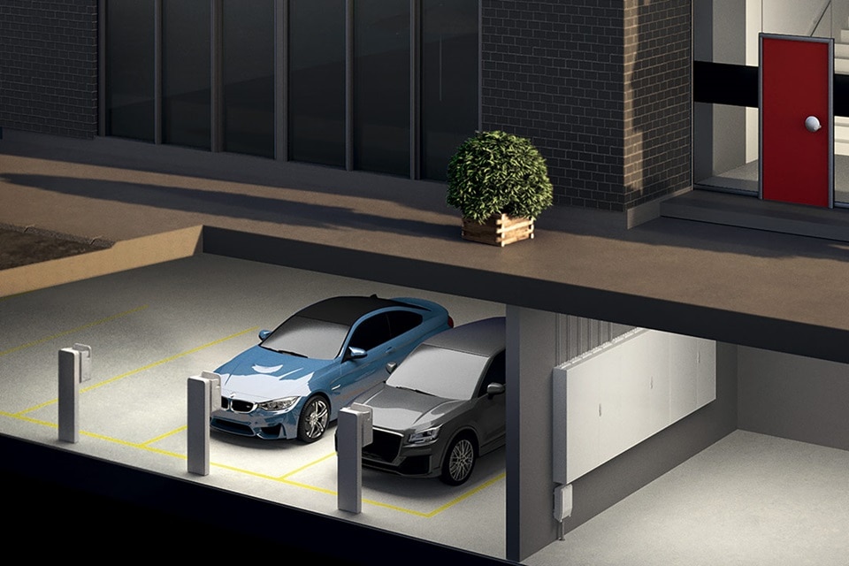 Nächtliche Ansicht eines gut beleuchteten Tiefgaragenparks mit zwei Autos und architektonischen Details