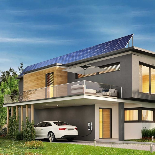 Modernes Haus mit Solarmodulen und Ladestation für Elektroautos