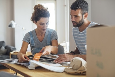 Eine Frau und ein Mann planen ihr Eigenheim gemeinsam an einem Tisch.