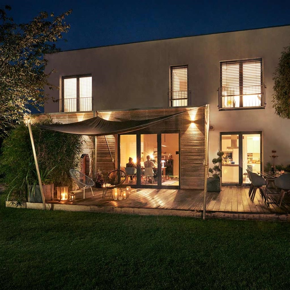 Modernes Haus mit Außenbeleuchtung und offener Terrassenbereich in der Dämmerung