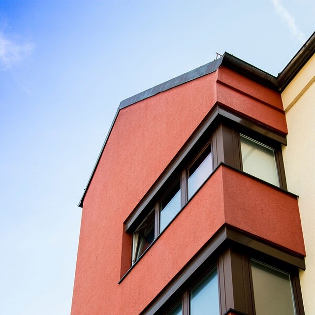 Moderne rote Gebäudefassade mit klarem Himmel