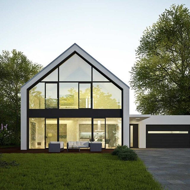 Modernes Haus mit großen Fenstern und einer Garage in der Dämmerung