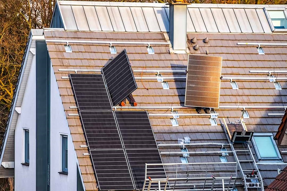 Hager Group Person installs solar panels on house roof