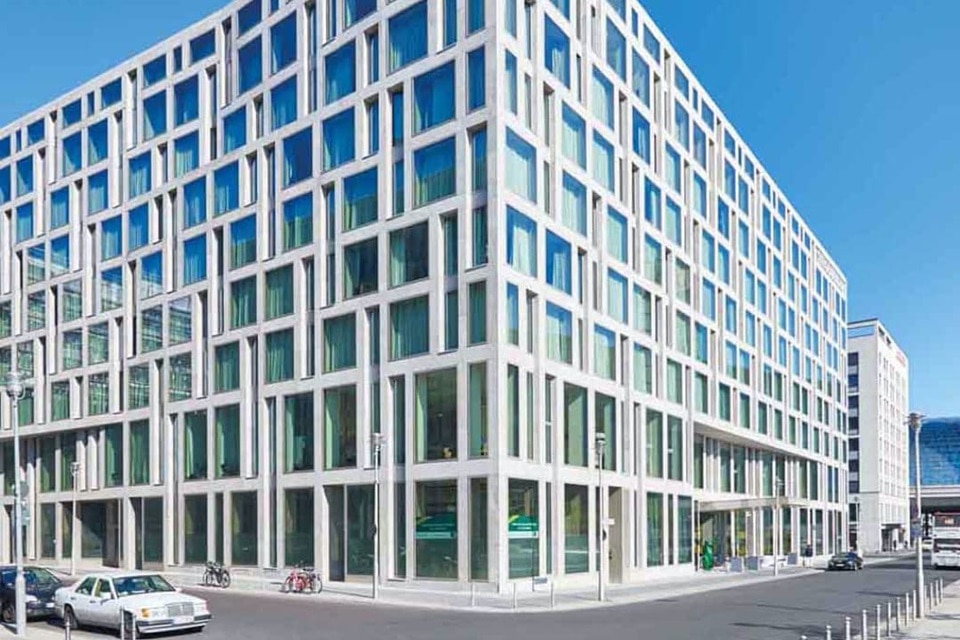 Modern commercial building with large glass windows and a grid facade on a sunny day