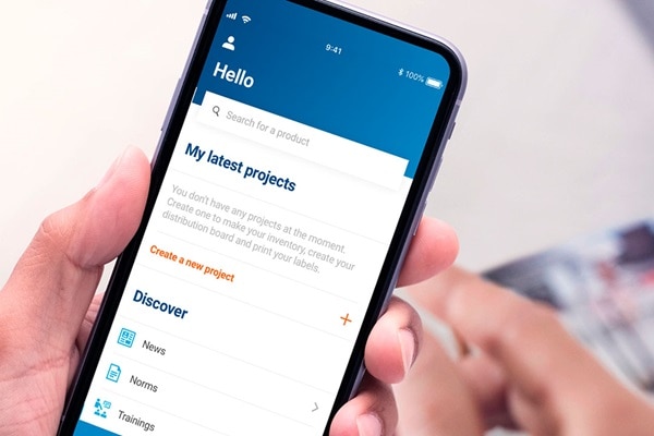 Person holding a smartphone displaying a project management app interface