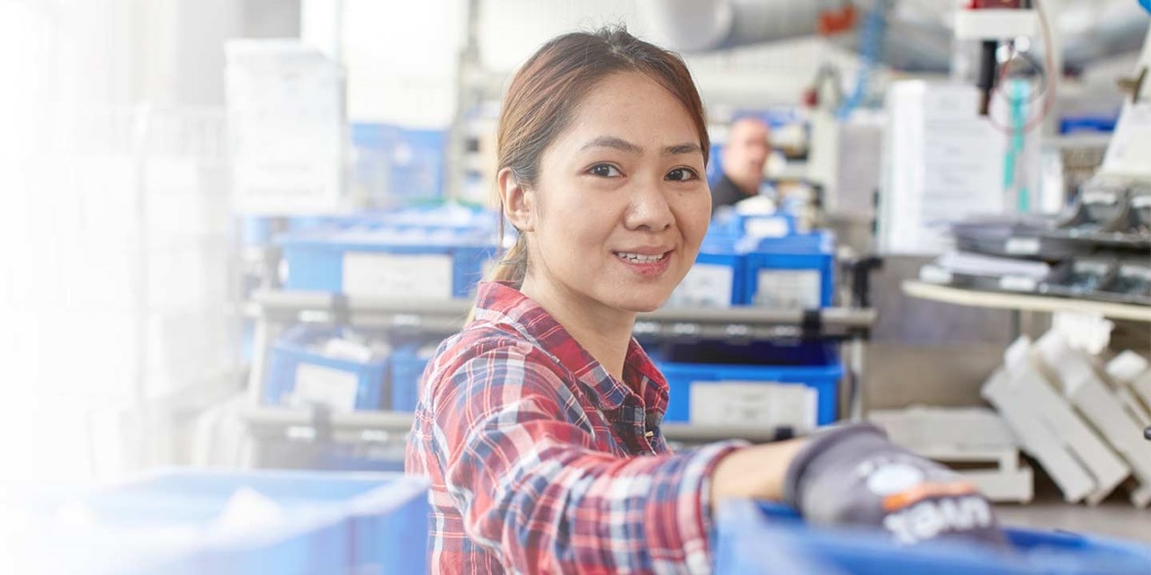 Employee working in an industrial environment with electrical components in the background