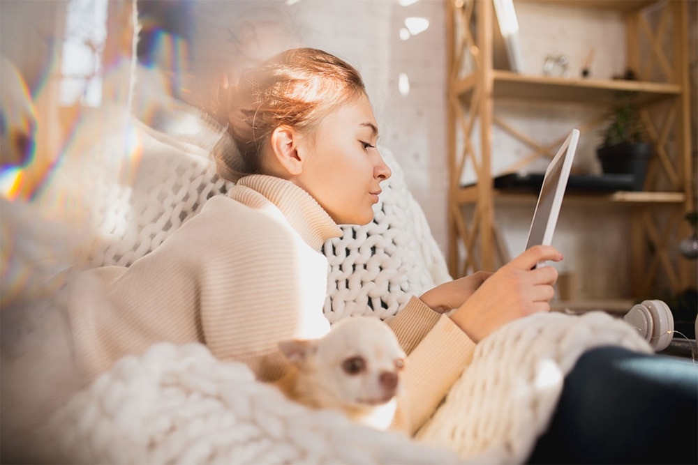 woman on couch reading from a tablet